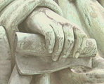 Relief: Eine Hand hält eine Pergamentrolle